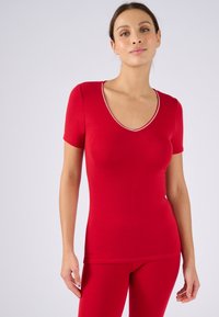 Rode top met korte mouwen en een diepe V-halslijn, met een contrasterende bies. Gemaakt van een soepele, rekbare stof die zich vormt naar het lichaam.