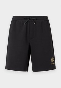 Shorts noirs longueur genou avec taille à cordon et petit logo jaune « A|X Armani Exchange » sur la partie inférieure de la jambe gauche.