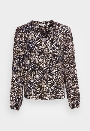 Bluzica dugih rukava crne boje s raspršenim točkicama u bež i svijetlo plavoj. Ima opušteni kroj i detalje s gumbima.