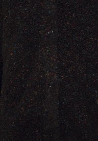 Czarny wełniany kardigan o teksturowanej, nakrapianej powierzchni z kolorowymi włóknami. Z przodu znajduje się pięć czarnych guzików.