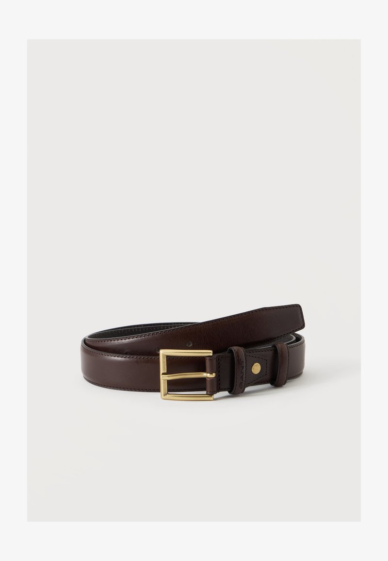 Ceinture en cuir marron foncé avec une boucle rectangulaire en or, roulée à plat sur un fond blanc.