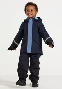 Navy waterproof jacket with light blue accents and reflective stripes, paired with matching pants and black boots, designed for children.