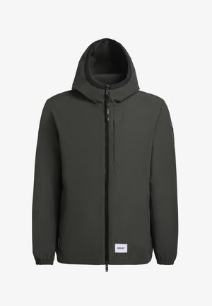 Donkergroene gewatteerde jas met een volledige rits aan de voorkant, elastische manchetten en een textuurafwerking. Bevat een logo patch nabij de zoom.