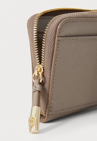 Bruin gestructureerde portemonnee met gouden ritssluiting, gladde leren bies en een decoratieve metalen trekker. Heeft kaartsleuven en een compact design.