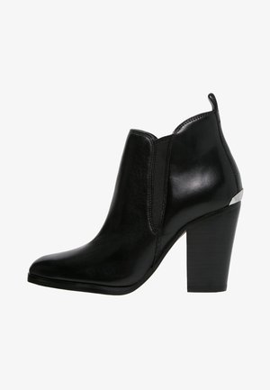 Schwarze Leder-Stiefelette mit spitzer Zehenpartie, elastischen Seiteneinsätzen und einem hohen Blockabsatz. Verfügt über einen metallischen Akzent am Absatz.