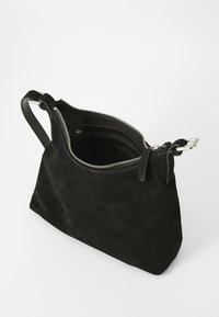 Zwarte suède handtas met een ritsopening aan de bovenkant, voorzien van twee leren handvatten en een interieur met vakken. Glad textuur en minimalistisch ontwerp.