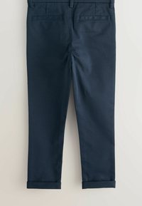 Tengerészkék pamutnadrág egyenes szabással, két hátsó zsebbel és felhajtott szegéllyel a laza megjelenésért. Sima textúrájú, minimális díszítéssel.