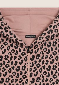 Hoodie rose avec un imprimé léopard noir, fabriqué en tissu doux, avec une fermeture éclair à l'avant et une capuche doublée. Étiquette de marque visible.