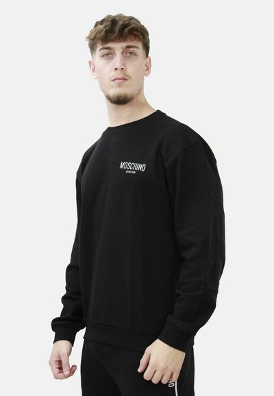 Felpa nera Moschino in cotone misto, design a girocollo, con logo bianco sul lato sinistro del petto e polsini e orlo a coste.