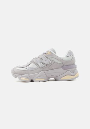 Light gray and beige athletic sneaker with textured sole, mesh and suede upper, and "N" logo on the side.