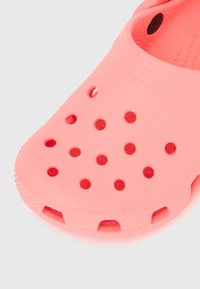 Κορ αλί ροζ διάτρητο λαστιχένιο τσόκαρο με στρογγυλερή μύτη και οπές αερισμού στην κορυφή και τις πλευρές.