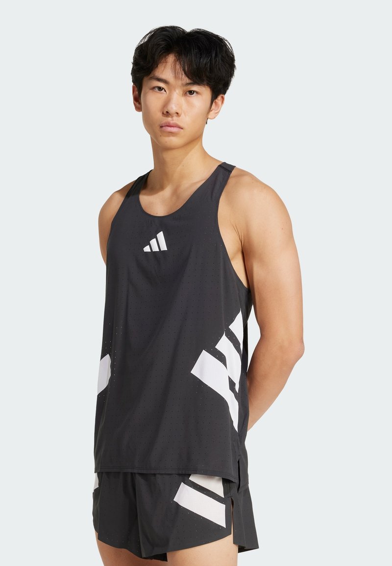 Débardeur de sport noir avec des rayures diagonales blanches, doté d'un col rond et d'une texture perforée. Associé à un short assorti.