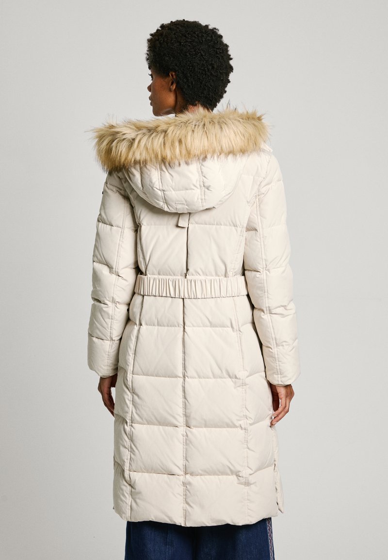 Gepolsterter langer Mantel in hellem Beige mit Kunstfellkapuze. Verfügt über eine taillierte Taille und eine gesteppten Textur. Die Rückansicht zeigt vertikale Nähte und Taschen.