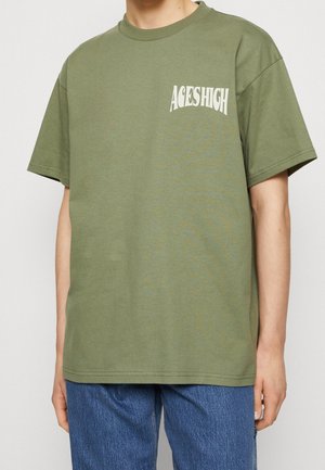 Olive green short-sleeved t-shirt, made of cotton, featuring a white graphic print "ACES HIGH" on the left chest. Casual fit.