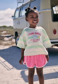 Green and white striped short-sleeve shirt with "FUN DAYS AT THE TENNIS COURT" text, paired with pink terry shorts, white trim.