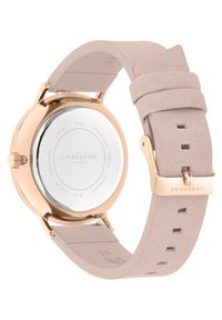 Montre ronde avec un boîtier en acier inoxydable rose doré, un bracelet en simili cuir beige et un fond argenté poli. Elle présente une fermeture à boucle simple.