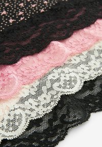 Set čipkastih tekstila koji uključuje crnu, ružičastu, bijelu i uzorčanu crnu tkaninu s malim srcima. Teksturirani rubovi s cvjetnim uzorcima.