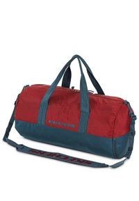 Bolsa de viaje roja y teal con cierre de cremallera, correa ajustable y asas en la parte superior. Presenta el logo de "SKECHERS" en azul. Tela texturizada.