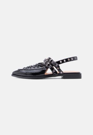 Chaussure plate en cuir verni noir avec bout pointu, brides à double boucle et détails œillets le long de la tige et de la bride de cheville.