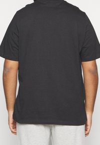 Svart bomull T-shirt med klassisk passform, korta ärmar och rund halsringning. Slät textur, inga synliga mönster eller detaljer.