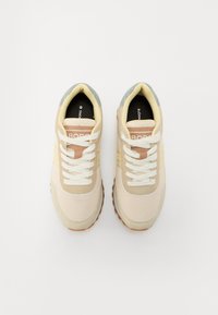 Lettvekt sneakers i beige, krem og lys blå. Har mesh- og skinnmaterialer, hvite snørebånd og en teksturert gummisåle.