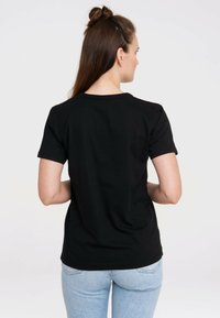 Black cotton t-shirt with short sleeves and a round neckline. Plain design; no visible logos or patterns; smooth texture.