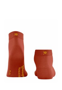 Chaussettes rouges jusqu'à la cheville avec une texture lisse. Présente un logo et un texte jaunes sur le côté. Conception à orteils sans couture pour le confort et le maintien.