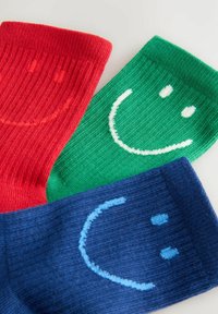 Drei Paare gerippte Socken: rot mit einem Lächeln, grün mit einem Lächeln und blau mit einem Smiley und zwei Punkten für die Augen.