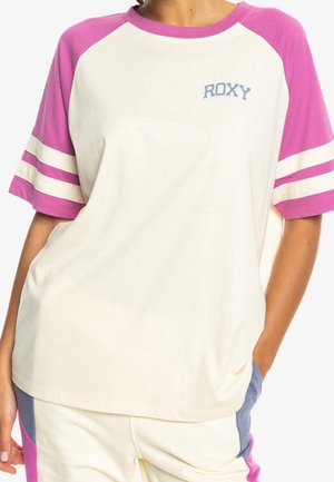 Short-sleeve t-shirt with a cream body and pink textured raglan sleeves, featuring white stripes and "ROXY" logo in light blue.