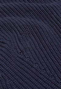 Strukturiertes marineblaues Strickgewebe mit abwechselnden, gerippten und glatten Abschnitten, weicher Textur und gleichmäßigen Nähten.