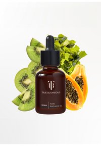 Bruine glazen pipetfles gelabeld "True Botanicals Pure Radiance Oil," met groene kiwi, gele papaja en een achtergrond van groene bladeren.
