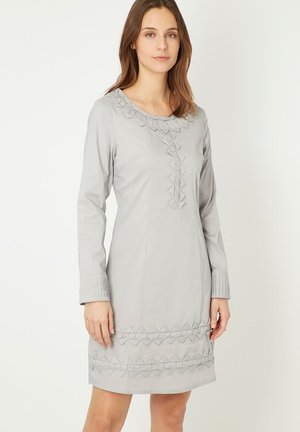 Vestido gris claro con mangas largas, que presenta patrones geométricos texturizados a lo largo del escote y el dobladillo, con puños de manga plisados.