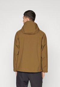 Veste étanche marron avec capuche, présentant une texture lisse et un design simple. Elle a une coupe droite et une finition mate.