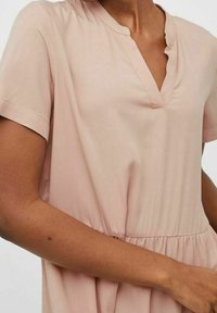 Short-sleeve, light pink dress with a V-neckline, gathered waist, and smooth, soft fabric. No visible patterns or embellishments.