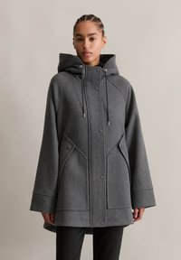 Manteau en mélange de laine gris avec capuche, doté d'une fermeture éclair à l'avant, de boutons-pression, de poches latérales et d'une coupe décontractée. Détails de couture sur les manches.
