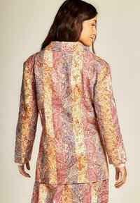 Giacca a due pezzi in tessuto leggero con un vivace motivo paisley nei toni del rosa, oro e blu. Vestibilità aderente con maniche lunghe.