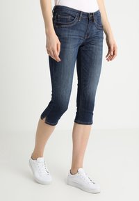 Mörkblå denim capri-jeans med en figurnära design, kortad nederkant, femfickorsstil och subtila sömnadsdetaljer.