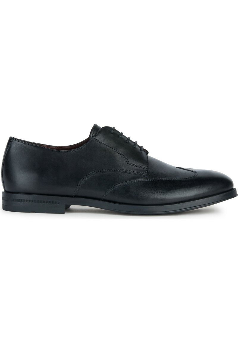 Chaussure de ville noire en cuir avec une texture lisse, dotée d'un bout arrondi, de coutures subtiles et d'une semelle discrète. Design classique à lacets.
