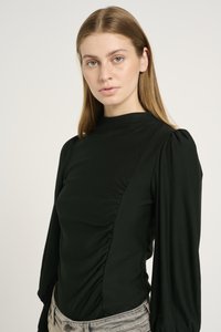 Black long-sleeve top with a high neckline, featuring side ruching and puffed sleeves, paired with light grey jeans. Smooth fabric texture.