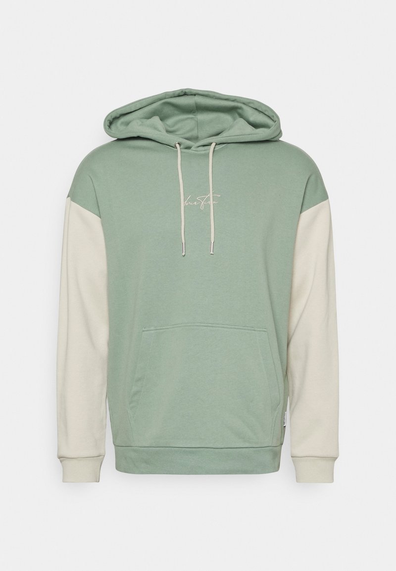 Sweat à capuche vert clair avec manches blanches, poche avant, cordons de serrage réglables et petit texte en script blanc sur la poitrine.