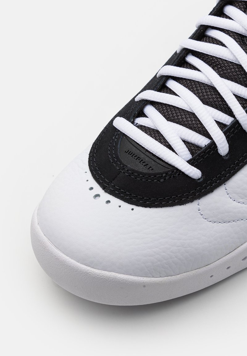 Białe i czarne sneakersy z teksturowanej skórzanej cholewki, z siateczkowym językiem i kontrastującymi sznurówkami. Posiadają widoczne przeszycia oraz perforowany detal.
