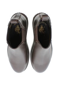 Botas de tobillo de cuero marrón con paneles laterales elásticos, puntera redonda y suela texturizada. El interior presenta detalles del logo sobre un fondo negro.