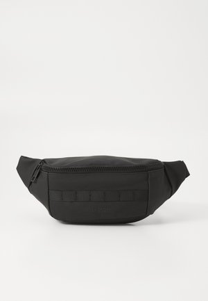 Black nylon fanny pack with a zip closure, flat front panel, and woven strap accents. Features embossed logo detail and rounded edges.