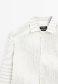 Chemise blanche à boutons avec fines rayures verticales grises et col classique, étiquetée Massimo Dutti.