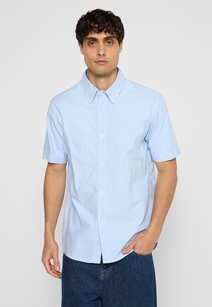 Lichtblauw kortarm overhemd met een button-down kraag, gemaakt van katoen stof, heeft een klein logo op de linkerkant van de borst en een knoopsluiting aan de voorkant.