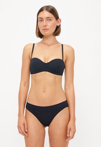 Svart bikinitsett med formet, underwire topp med tynne stropper og matchende lavt skjærte truser; glatt, elastisk stoff med minimal detaljering.