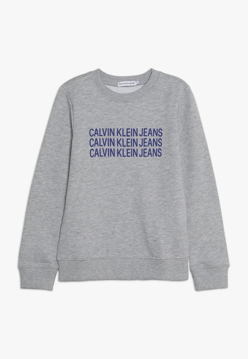 Sweat-shirt gris clair à col rond avec manches longues et « CALVIN KLEIN JEANS » imprimé en bleu, répété trois fois sur le devant.