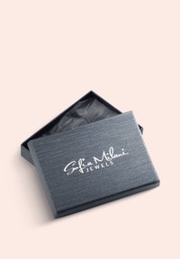 Grå texturerad smyckesask med ett öppet lock som avslöjar svart silkespapper inuti. Innehåller den vita logotypen "Sofia Milani JEWELS" på toppen.