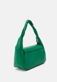 Zelená kabelka s měkkým, zkrouceným držadlem a strukturovaným obdélníkovým tělem na jednoduchém bílém pozadí.