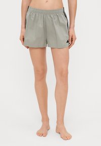 Svijetlosive sportske kratke hlače s elastičnom trakom, bočnim crnim prugama i malim crnim logotipom s lijeve strane.